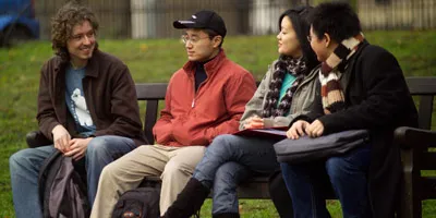 four students sitting on bench