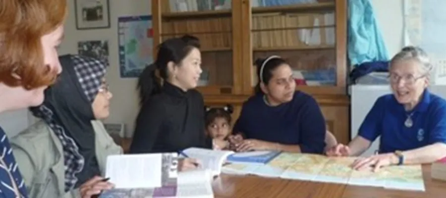 A group of women sit around at a table at the International Women's Group