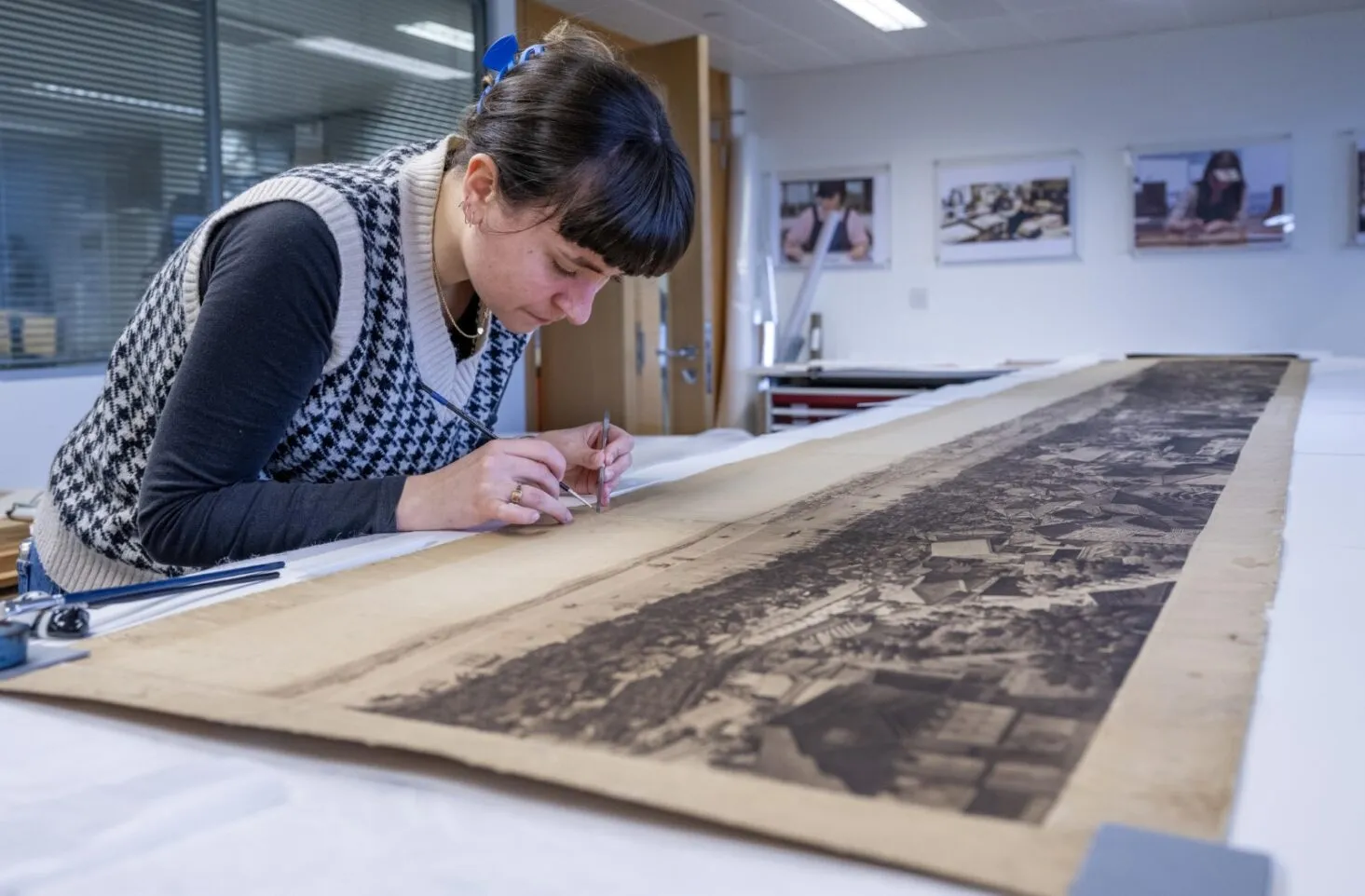 Conservator Amanda Dodds makes repairs to Barker's panorama of Constantinople laid out on a white table