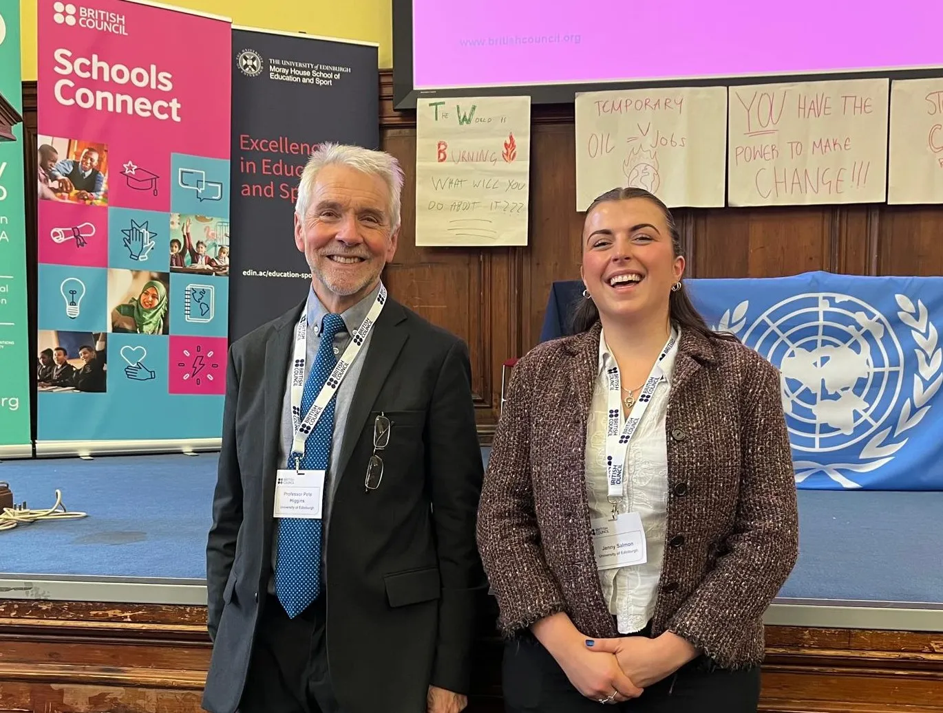 Two academics in front of an information panel