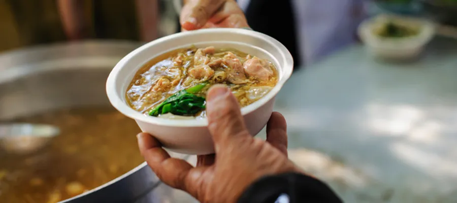 Picture of hands giving a bowl of soup