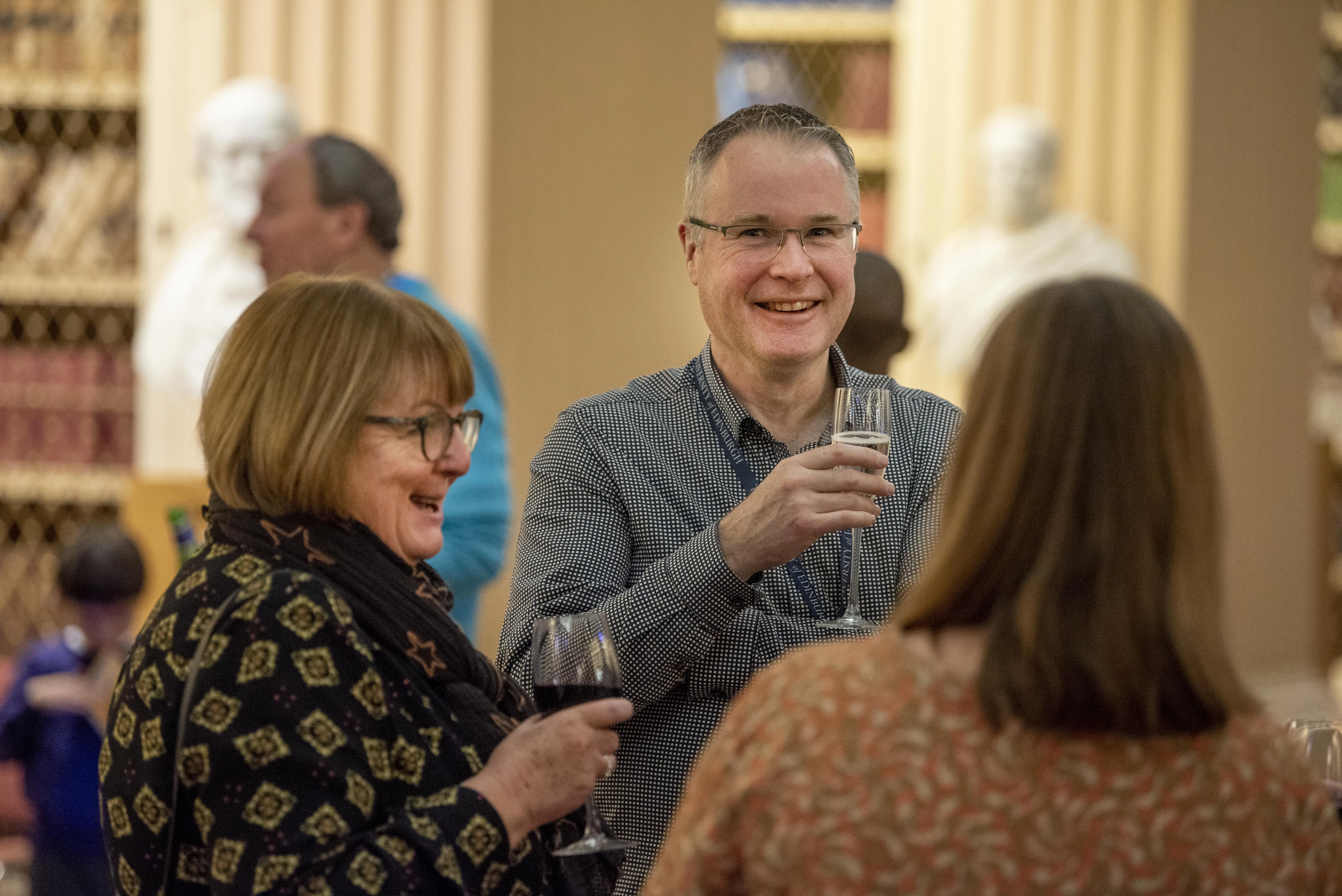 A group are chatting happily in the Playfair Library at the long service ceremony