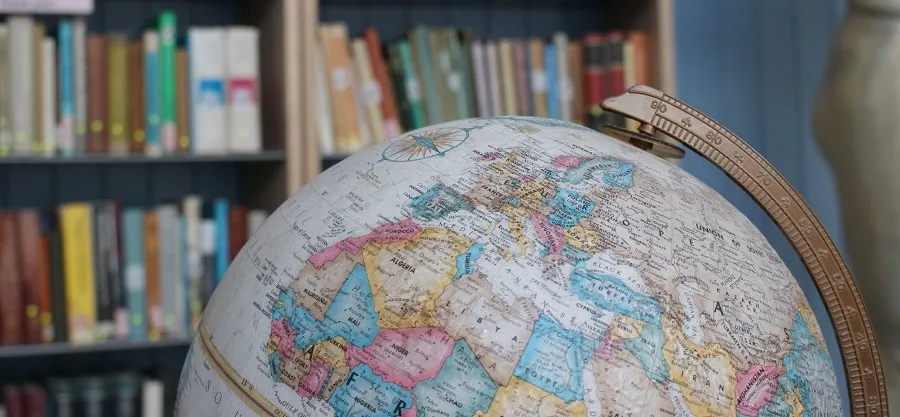 A globe pictured against the backdrop of a library