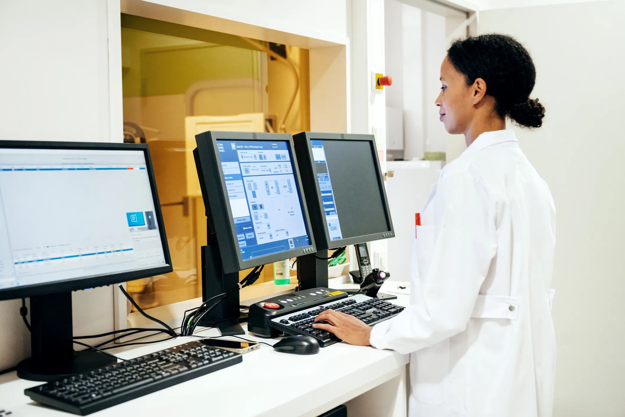 Female doctor in white coat looking at data on a computer screen