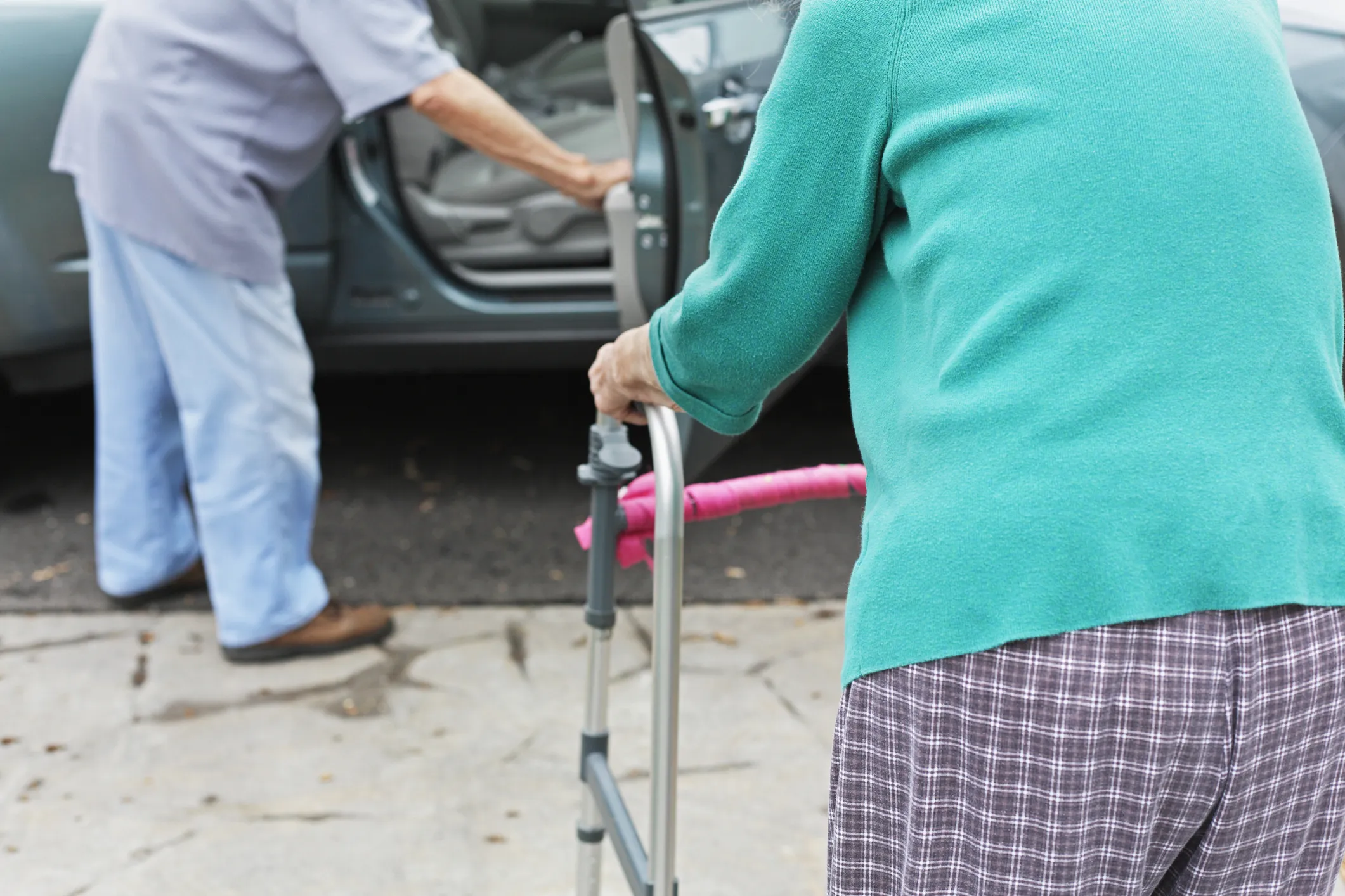 Stock image of an elderly couple getting into a car