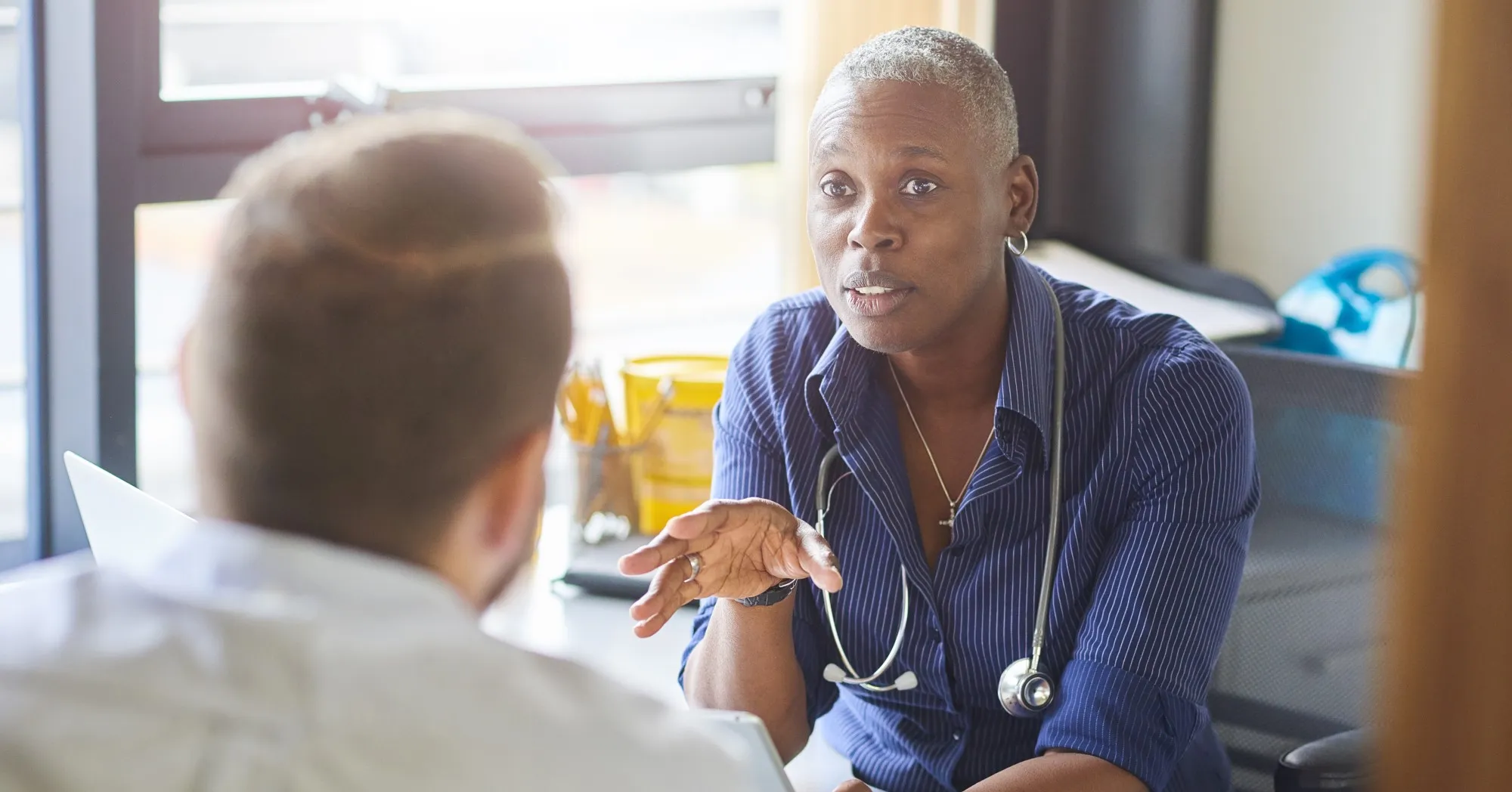 Female doctor talking to male patient in GP surgery