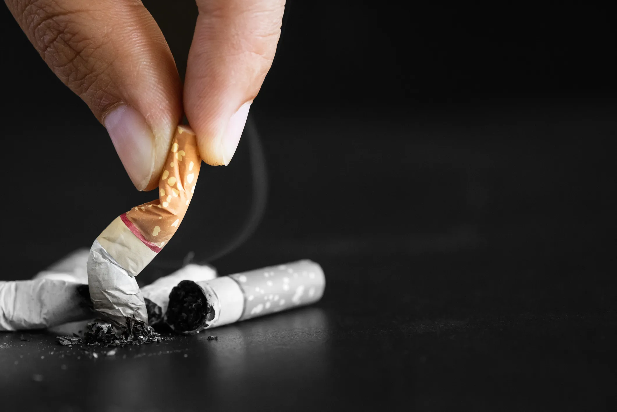 Image of person stubbing out a cigarette