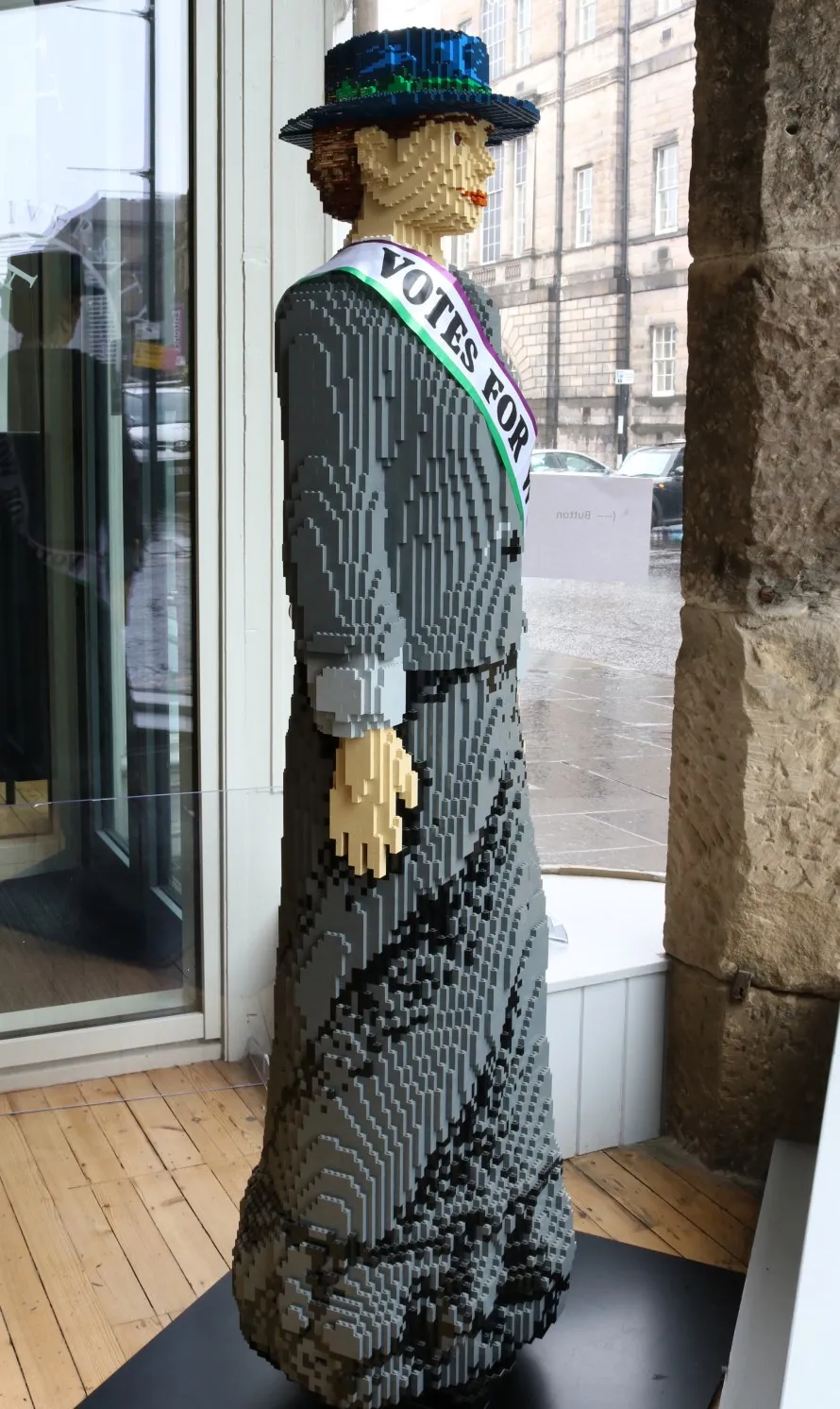 Image a life sized lego brick statue of a suffragette
