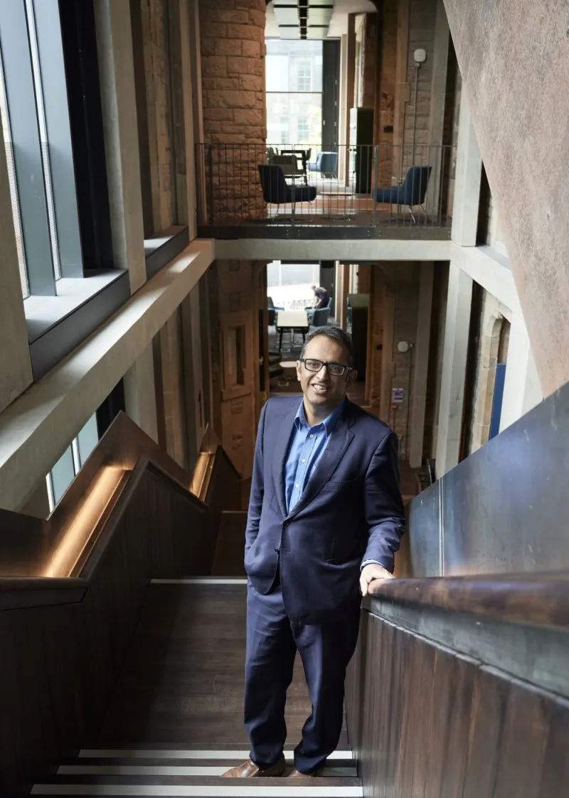 Image of Kev Dhaliwal standing on a staircase in Edinburgh Futures Institute