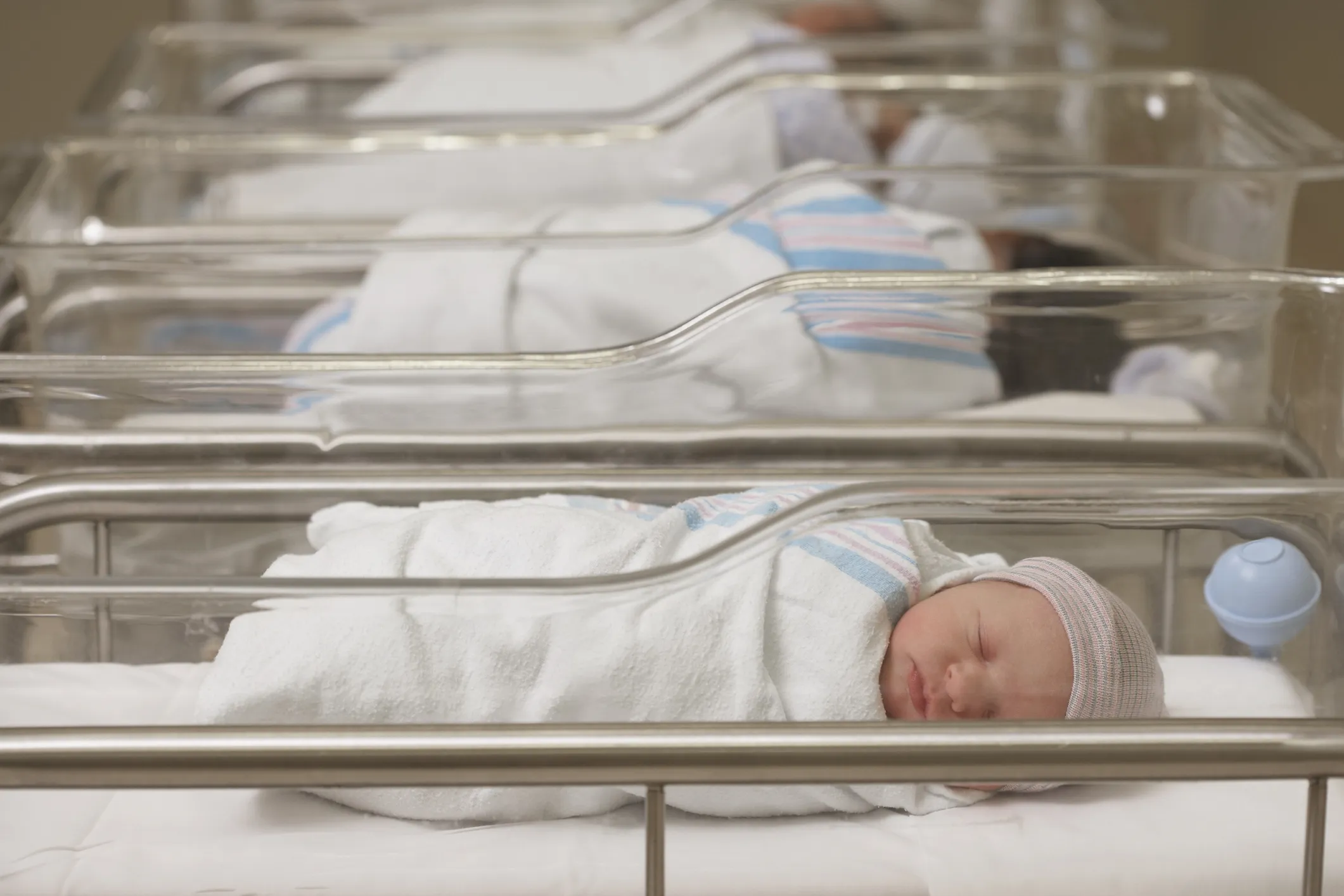 A row of cots of in a hospital containing newborn babies