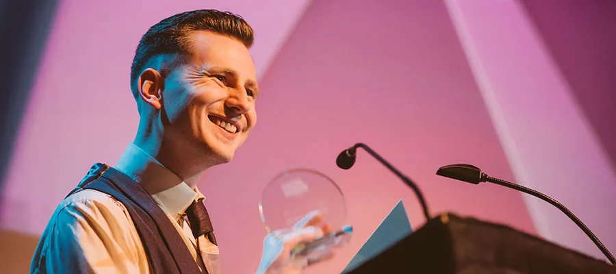 Photo of a man holding a EUSA Teaching Award
