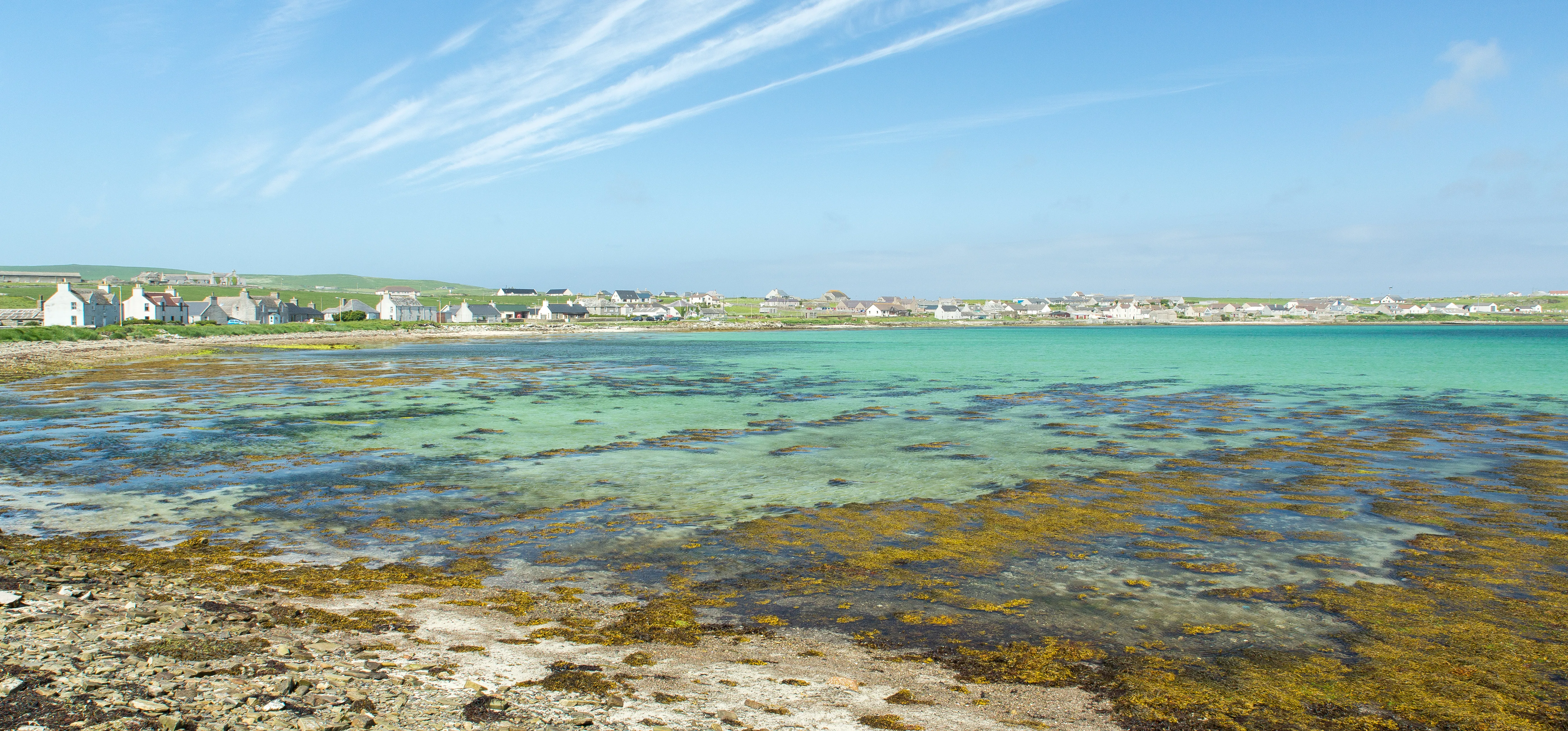 A photograph of the Bay of Pierowall, Westray, Orkney, Scotland, UK, in bright sunlight
