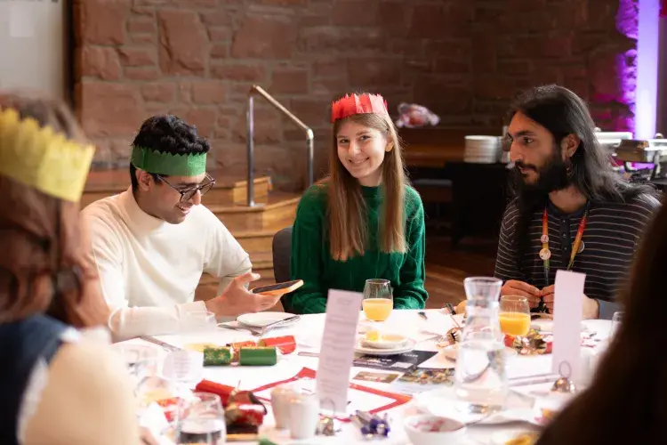 Students sit around a table at Festive Lunch
