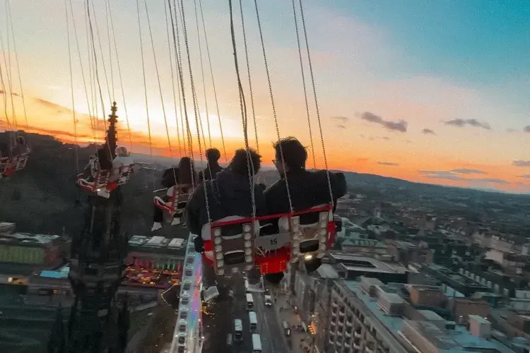 An elevated look at the city centre taken from a swing ride, high above Edinburgh's Princes Street