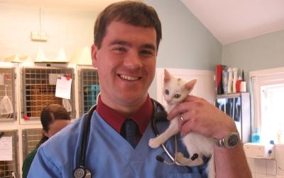 A vet poses with a kitten
