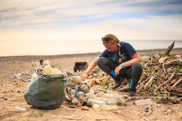 Cal Major sifting through plastic debris on a beach