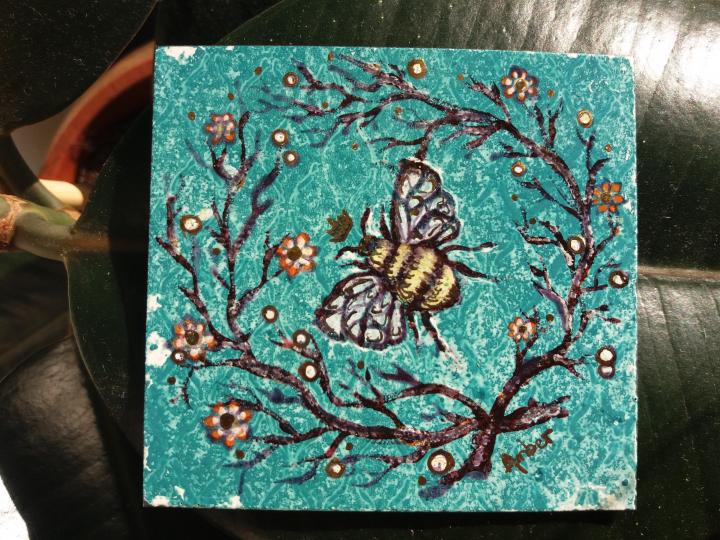 A canvas of a Queen Bee, the background of the canvas is green and there are tree branches with white and orange flowers on the branches. The queen bee is in the centre of the canvas.