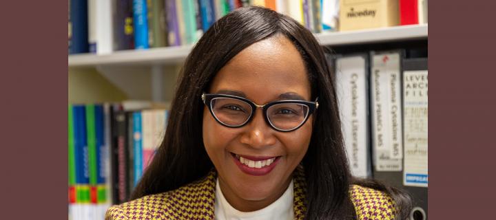 Professor Francesca Mutapi, a black woman with dark hair and glasses, smiling toward the camera