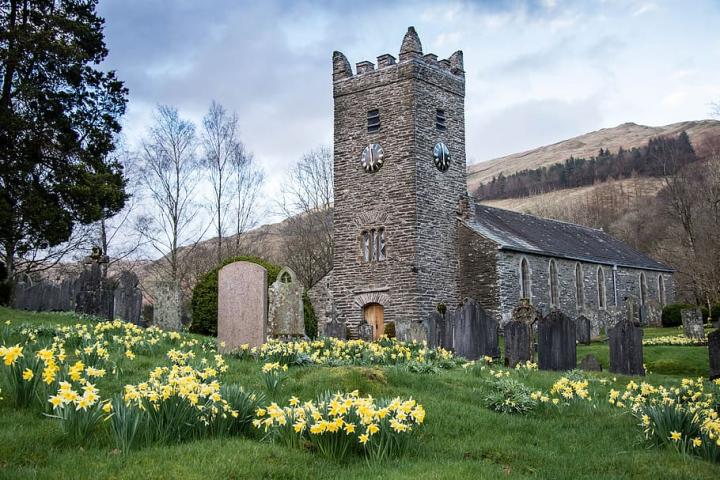 Photograph of a church, with daffodils blooming in the church grounds