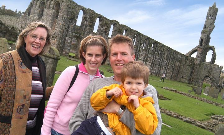 Family of 4 stood in front of a Scottish Abbey