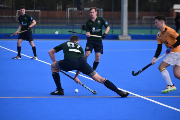 Image of male hockey player making a pass with hockey ball 