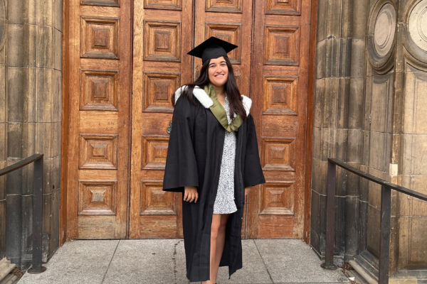 Photo shows Sheela in graduation robes outside McEwan Hall