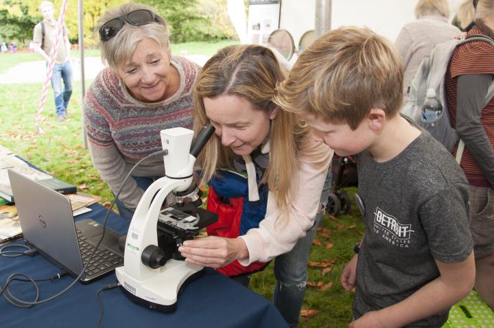 Family group looking down a microscope