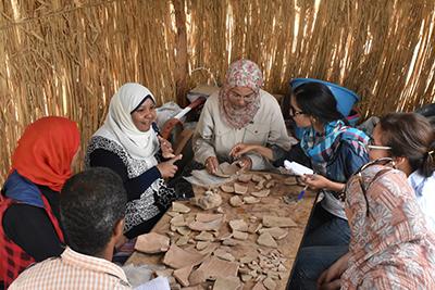 A group of women take part in a training session on pottery recording and conservation at the site of Nubt