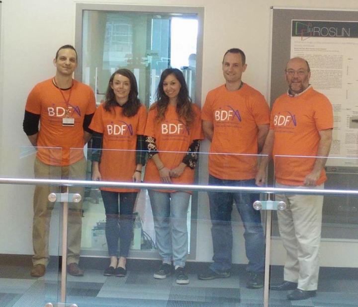 Group of people wearing orange clothing with BDFA logos