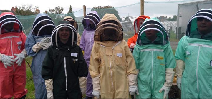 Pupils in beekeeping suits
