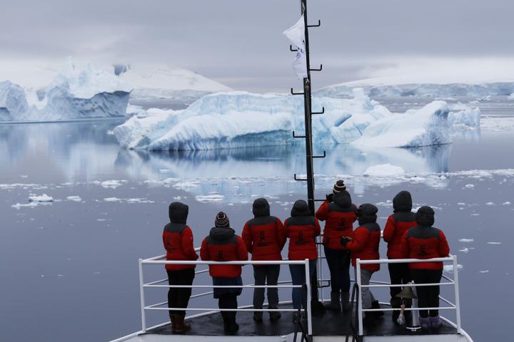 Antarctica expedition boat sailing past icebergs