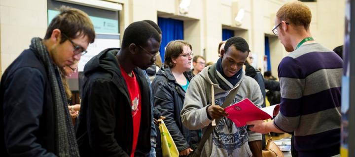 Photo of University staff talking to students at the 2015 Postgraduate Study Roadshow