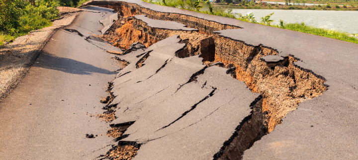 A bitumen road cracked and in upheaval from an earthquake