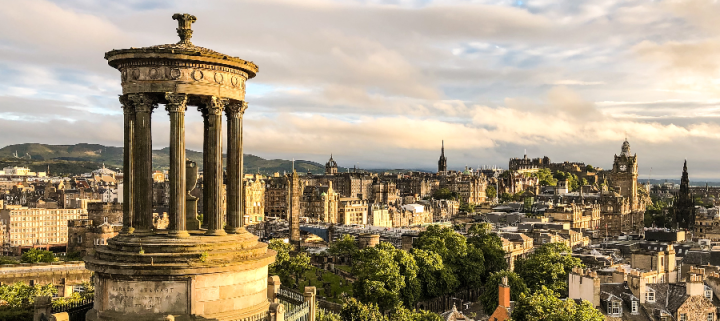 A view of Edinburgh city from Calton Hill at sunset, with the Dugald Stewart Monument in the foreground