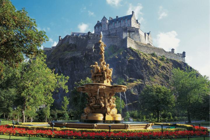 photo shows princes street gardens with the fountain and edinburgh castle in the background