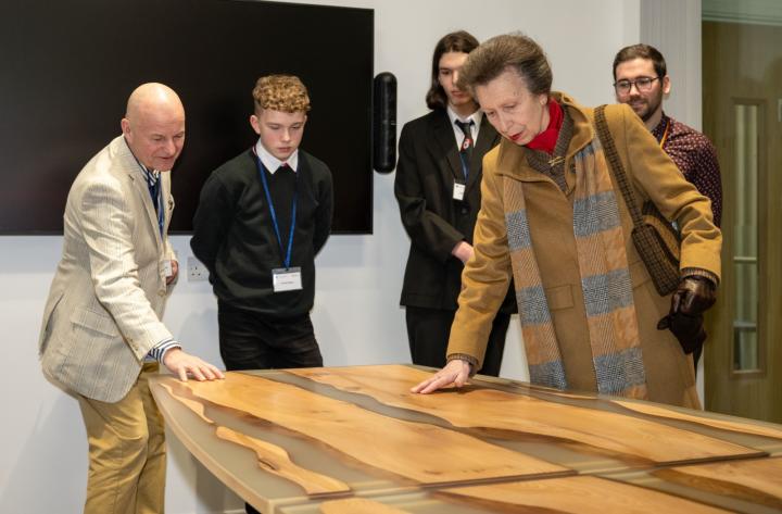 The Chancellor admires the boardroom table made by Castlebrae pupils
