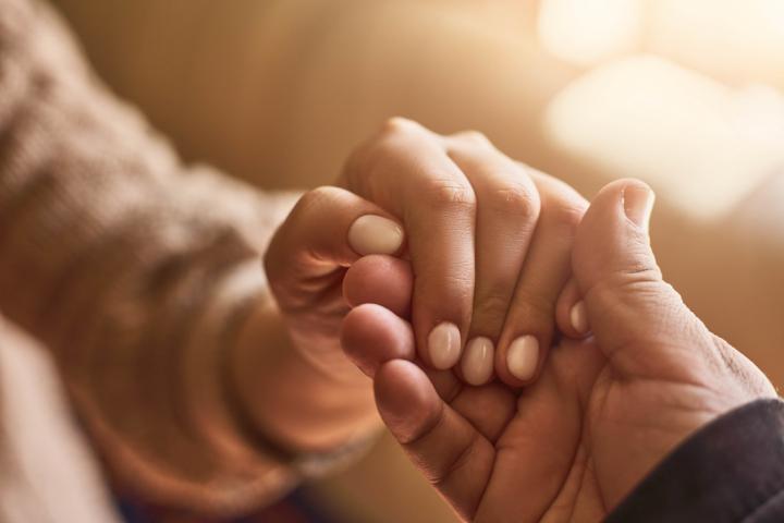 A photograph of one person holding out their hand to another