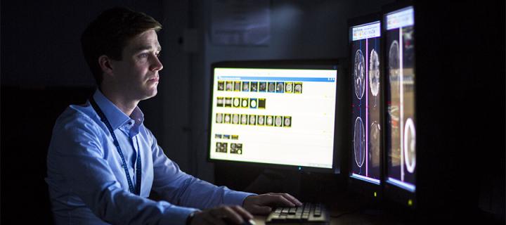 A consult neuroradiologist looking at a computer screen
