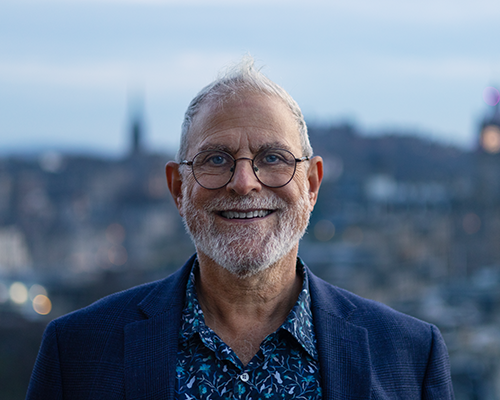 Photograph of Phil Wadler with Edinburgh city view backdrop