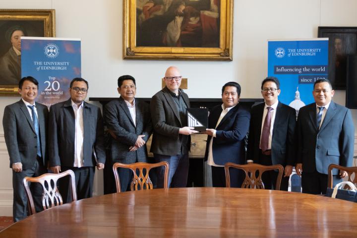 James Smith exchanges gifts with representatives from MoRA, IIIU, and the British Council