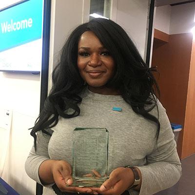 Photograph of Dominique Green holding her Equate Student-Institution Partnership Award