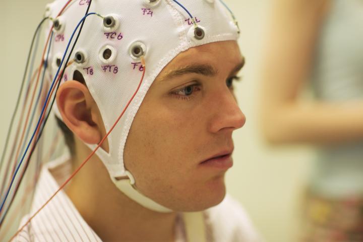 A young man connected to an EEG to conduce a brain scan
