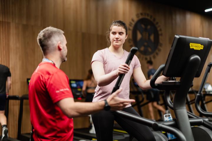Member of staff helping gym member with new kit