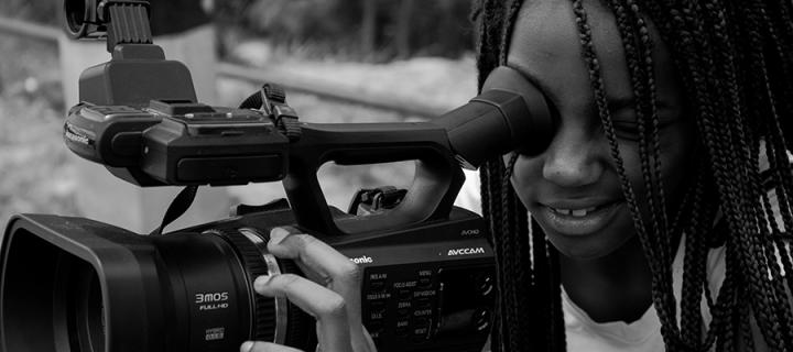 Photo of a filmmaker looking through a camera