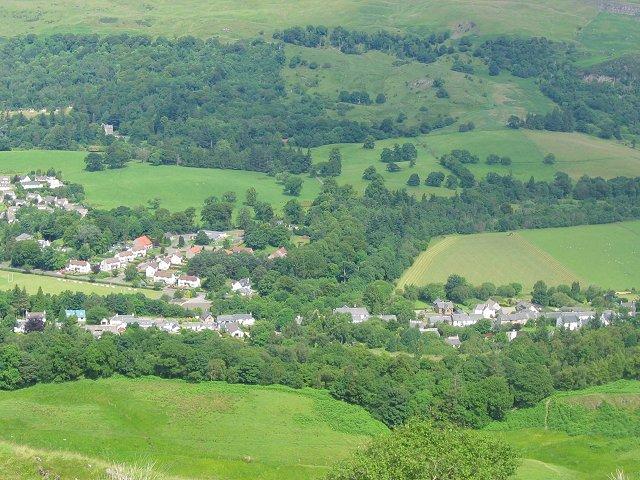 Aerial photograph of the hills and valleys of Fintry. In amongst the trees and green hills you can see the roofs of groups of houses