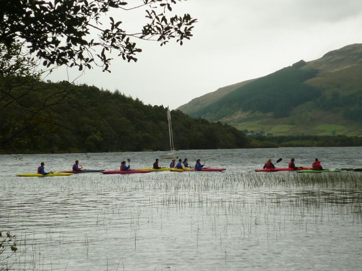 11 students in colourful kayaks on Loch Tay
