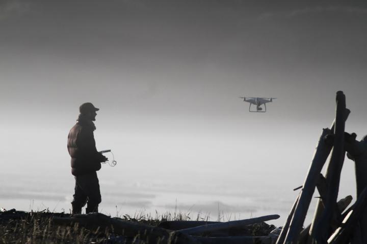 A man controls a drone in the mist
