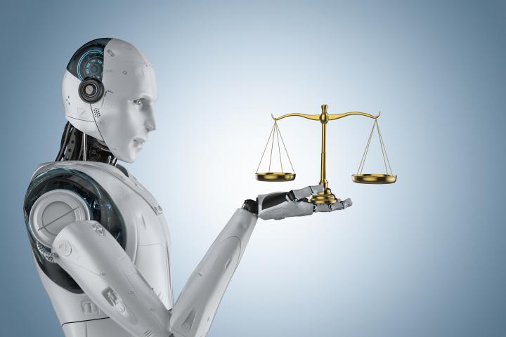 Robot holds scales of justice in hands