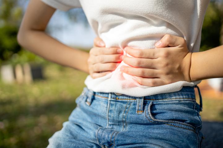 woman in discomfort holds her stomach