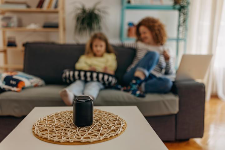 A child and adult listening to a smart speaker